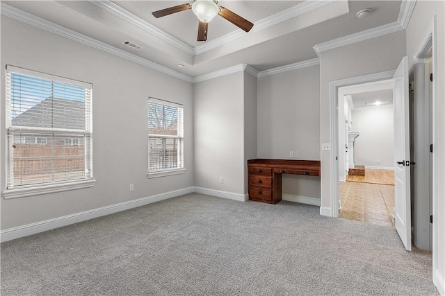 unfurnished bedroom with visible vents, light carpet, baseboards, crown molding, and a raised ceiling