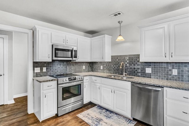 kitchen featuring visible vents, dark wood-style flooring, a sink, appliances with stainless steel finishes, and white cabinetry