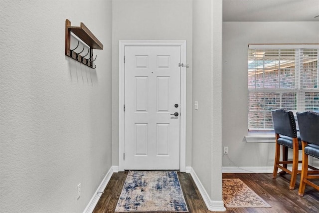 entryway featuring dark wood finished floors and baseboards