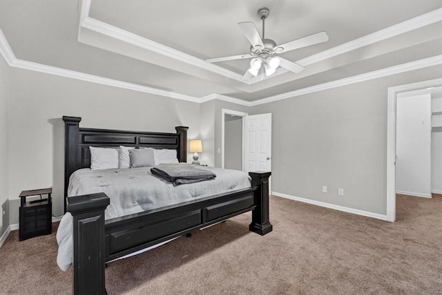 carpeted bedroom featuring baseboards, a ceiling fan, a tray ceiling, and ornamental molding