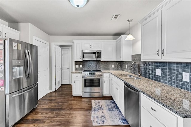 kitchen with a sink, stone countertops, tasteful backsplash, white cabinetry, and stainless steel appliances