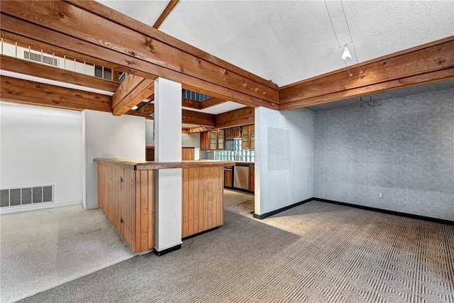 kitchen featuring visible vents, light colored carpet, a textured ceiling, and stainless steel dishwasher