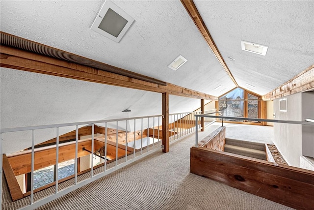 interior space with lofted ceiling, carpet flooring, a healthy amount of sunlight, and a textured ceiling