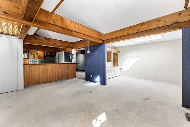 unfurnished living room with beam ceiling and carpet floors