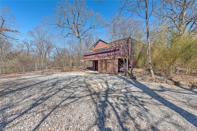 view of home's exterior with a wooden deck and fence