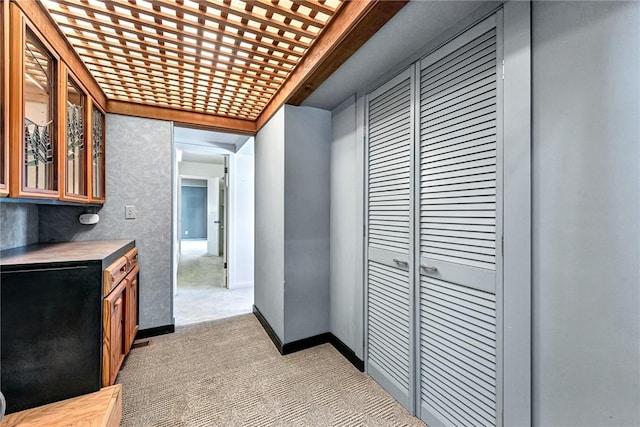 hall with light colored carpet and baseboards