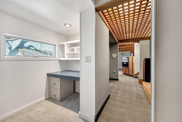 unfurnished office featuring light colored carpet and baseboards