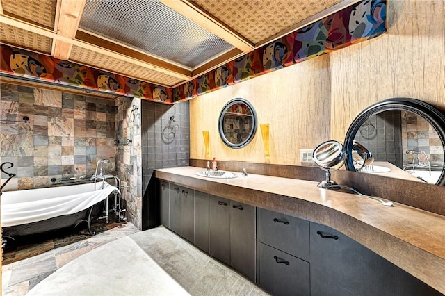 bathroom featuring tile walls, vanity, and a washtub