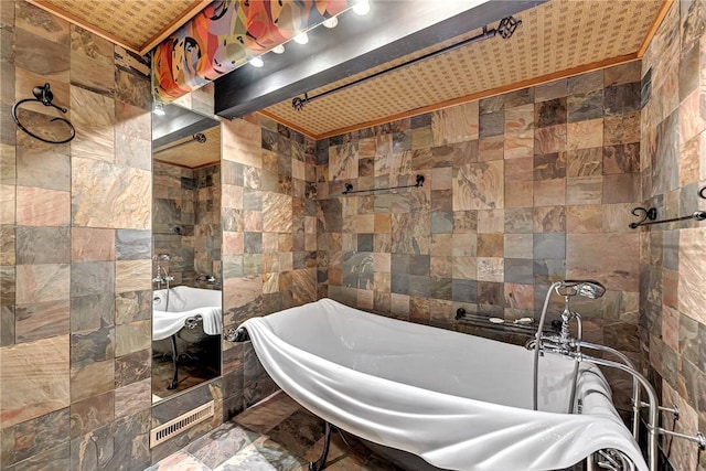 bathroom with a soaking tub and tile walls