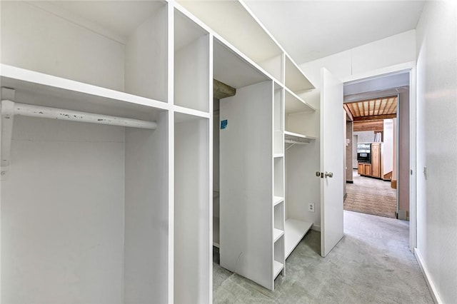 walk in closet featuring light colored carpet