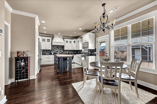 dining room featuring visible vents, crown molding, baseboards, and dark wood-style flooring