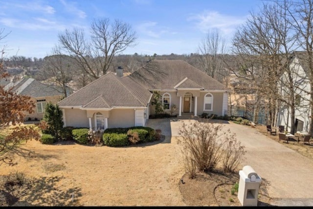 mediterranean / spanish-style home with driveway and a chimney