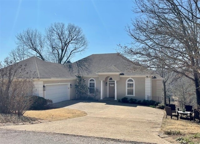 view of front of house featuring a garage, concrete driveway, and stucco siding