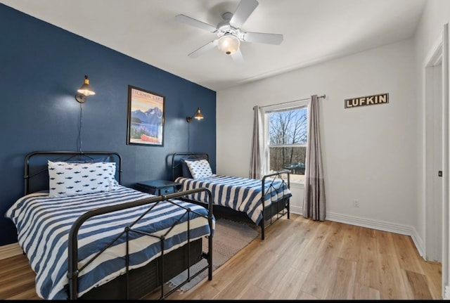 bedroom featuring a ceiling fan, wood finished floors, and baseboards