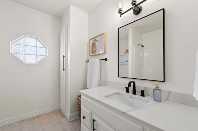 full bathroom with baseboards, walk in shower, and vanity