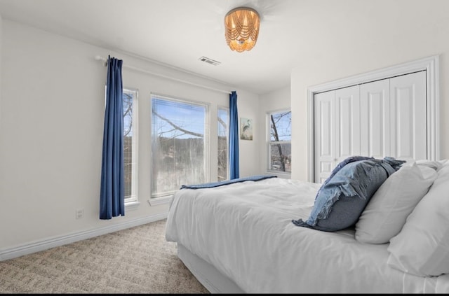 bedroom featuring visible vents, baseboards, carpet, and a closet