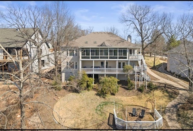 rear view of house featuring stairway and a chimney