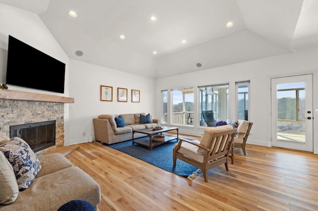 living area with a healthy amount of sunlight, a fireplace, and vaulted ceiling