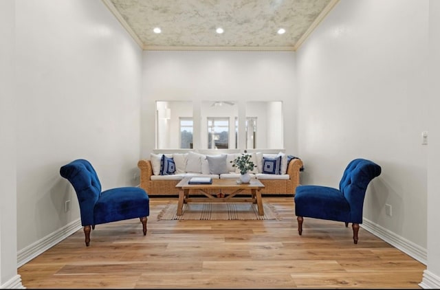 living area featuring recessed lighting, baseboards, light wood-type flooring, and ornamental molding