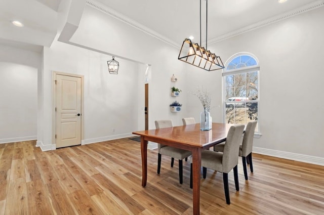 dining space featuring recessed lighting, crown molding, light wood-type flooring, and baseboards