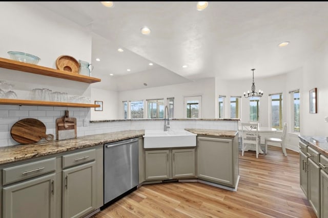 kitchen featuring a sink, stainless steel dishwasher, a peninsula, and gray cabinets