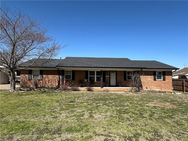 ranch-style house with fence, a front yard, a shingled roof, crawl space, and brick siding