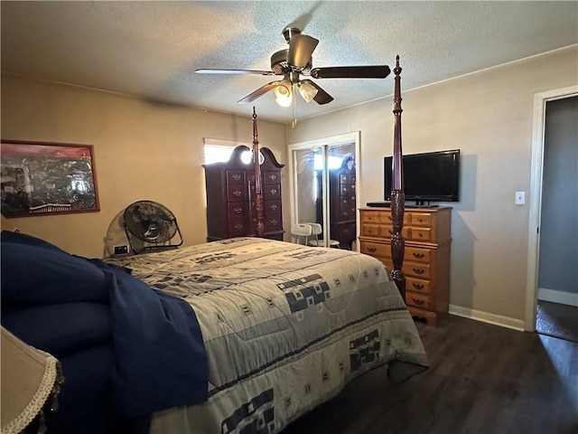 bedroom featuring dark wood finished floors, ceiling fan, baseboards, and a textured ceiling