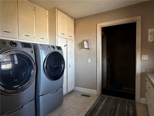 laundry room featuring visible vents, washer and dryer, cabinet space, light tile patterned floors, and baseboards