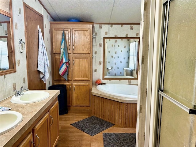 476359 791st Rd, Stilwell, OK 74960 - full bathroom featuring a garden tub, wood finished floors, a textured ceiling, a stall shower, and double vanity