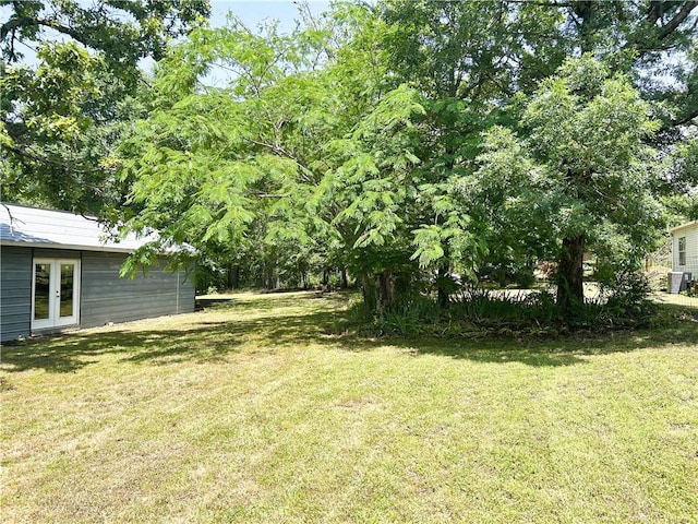 476359 791st Rd, Stilwell, OK 74960 - view of grassy yard with french doors and central air condition unit