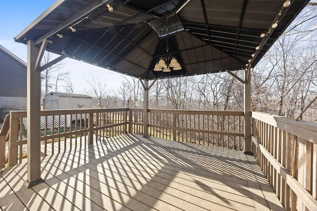 deck with an outbuilding, a storage unit, and a gazebo