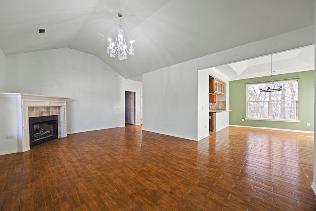 unfurnished living room with baseboards, a notable chandelier, wood finished floors, and a fireplace