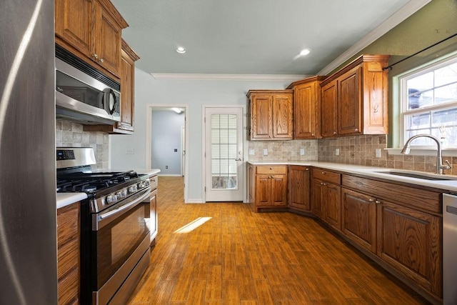 kitchen featuring a sink, stainless steel appliances, dark wood-type flooring, and light countertops