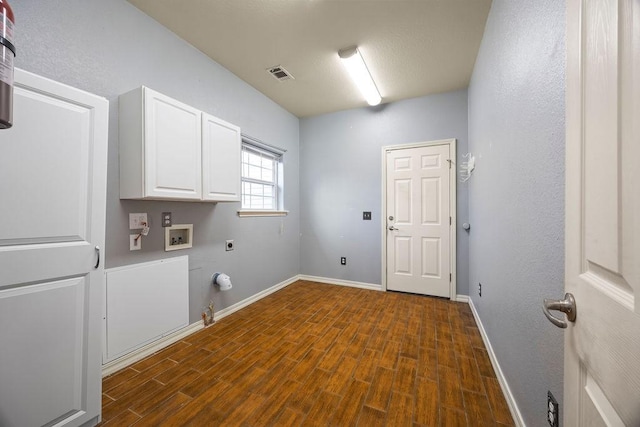 laundry area with visible vents, gas dryer hookup, dark wood finished floors, cabinet space, and electric dryer hookup