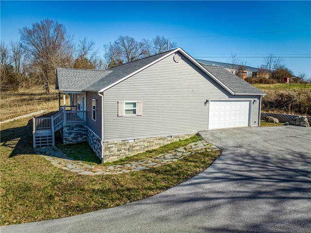 view of home's exterior with crawl space, an attached garage, a shingled roof, and aphalt driveway