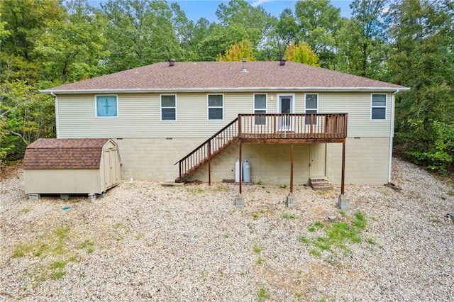 back of house with stairs, roof with shingles, a storage shed, a deck, and an outdoor structure