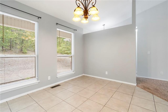 unfurnished room with light tile patterned flooring, visible vents, baseboards, and an inviting chandelier