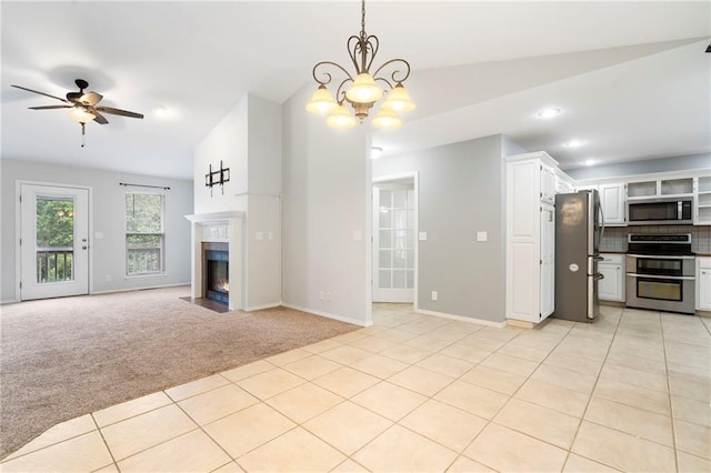 unfurnished living room featuring ceiling fan with notable chandelier, a fireplace with flush hearth, light colored carpet, and light tile patterned flooring