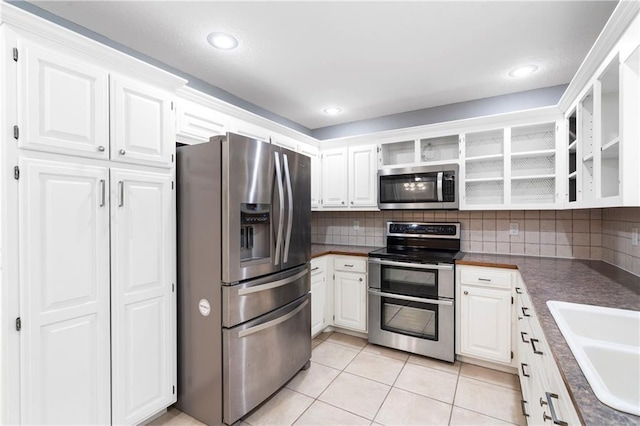 kitchen featuring a sink, stainless steel appliances, decorative backsplash, and white cabinetry