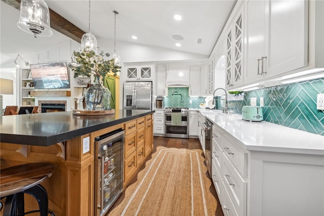 kitchen with beverage cooler, lofted ceiling with beams, custom exhaust hood, stainless steel appliances, and a sink