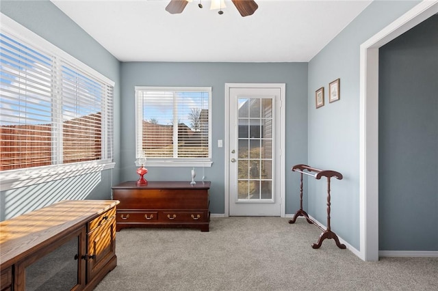 living area with carpet flooring, a ceiling fan, and baseboards