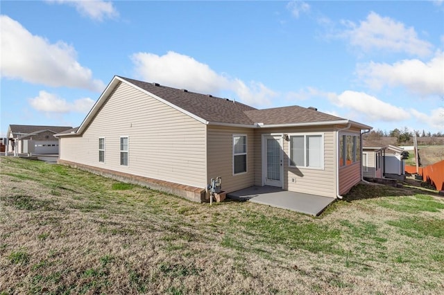 back of house with a patio, a yard, and roof with shingles