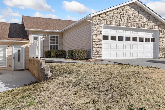 ranch-style house with roof with shingles, concrete driveway, and an attached garage