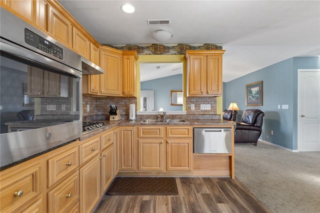 kitchen featuring visible vents, a sink, tasteful backsplash, stainless steel appliances, and lofted ceiling