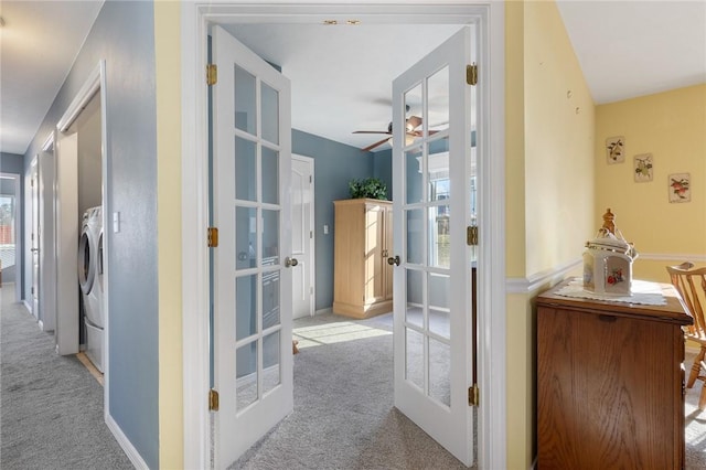 corridor with french doors, washer / dryer, and carpet flooring