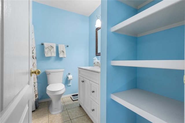 bathroom featuring baseboards, toilet, vanity, and tile patterned flooring