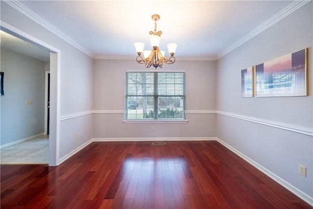 unfurnished room featuring ornamental molding, wood finished floors, baseboards, and a chandelier