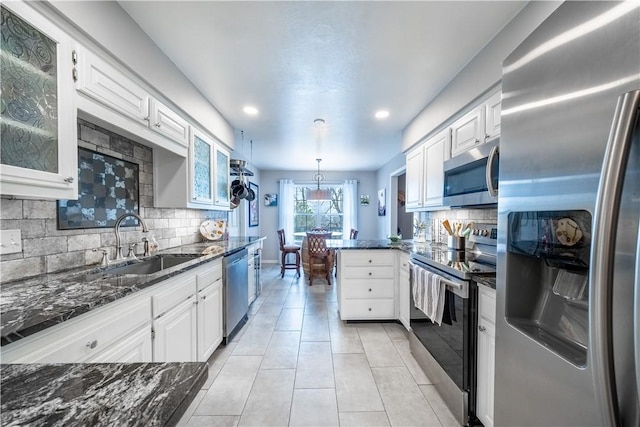 kitchen featuring white cabinetry, stainless steel appliances, glass insert cabinets, and a sink