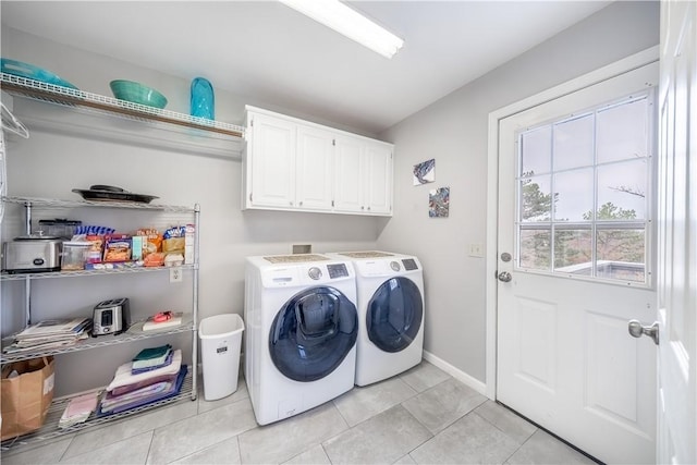 clothes washing area featuring light tile patterned floors, baseboards, cabinet space, and independent washer and dryer