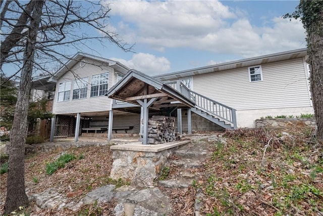 rear view of property featuring stairs